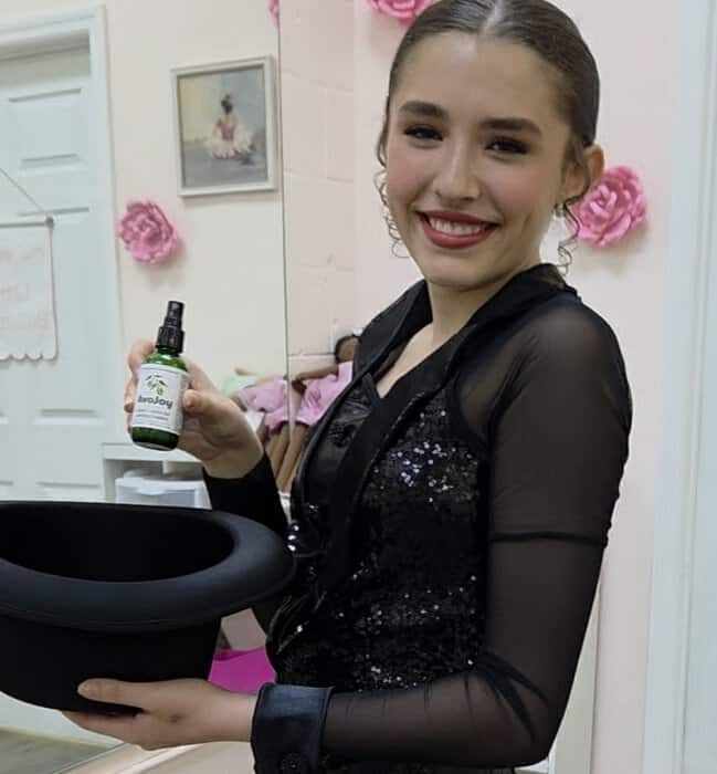 Competition dancer backstage holding her AvoJoy bottle